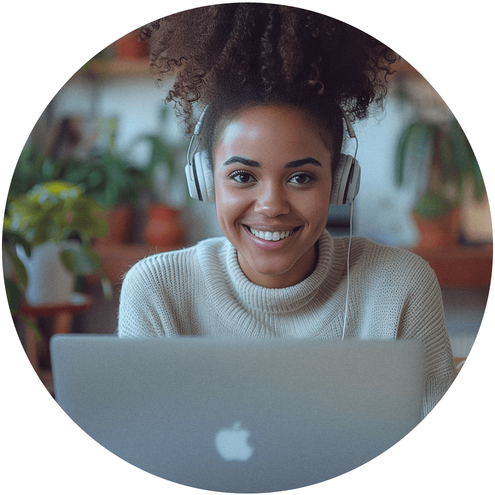 Woman with headphones smiling to the camera in front of a mac computer